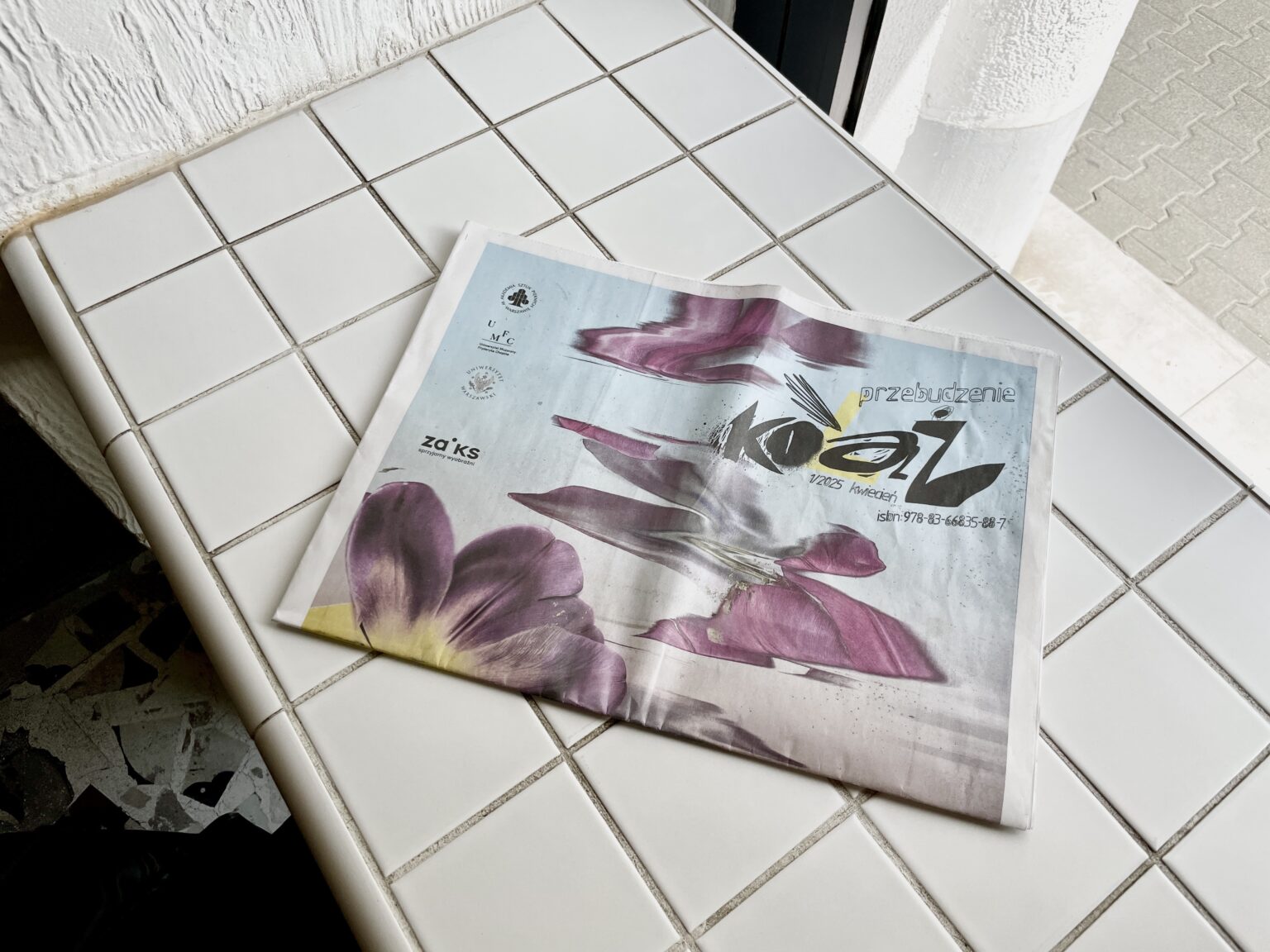 zdjęcie przedstawiające leżącą gazetę "Kolaż" na stole, widok z góry